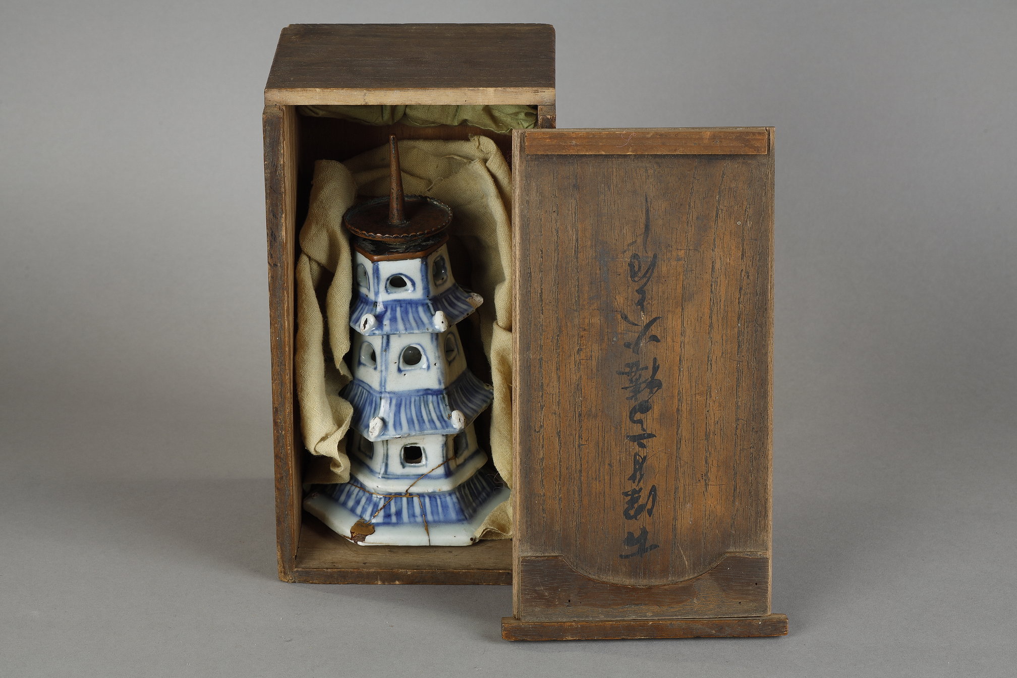 Rare "blue white" porcelain in the form of a pagoda surmounted by a copper spike for candle. originally a perfume burner . the lower part has been restored using the technique of Kintsugi mixture of lacquer and gold powder -  China late of the Ming dynasty  (1600/1630)   Old Japanese wooden box .